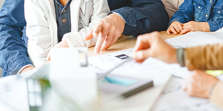 Plánování dřevostavby na klíč lidé kolem stolu plánují stavbu dřevostavby na klíč